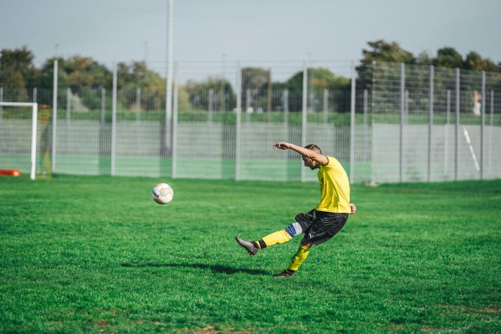 Soccer player kicking a ball during a sunset match